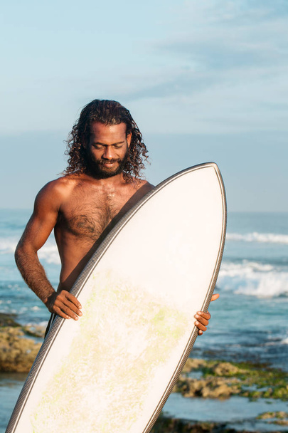 Surfer holding a surfboard - Foto, afbeelding