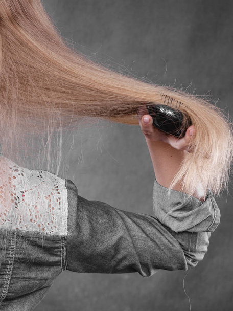 Blonde woman combing her hair. - Foto, Imagem