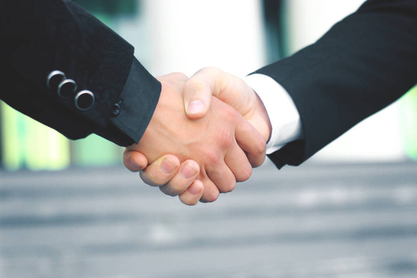 Закрывай. деловые партнеры по рукопожатию на размытом фоне
 - Фото, изображение