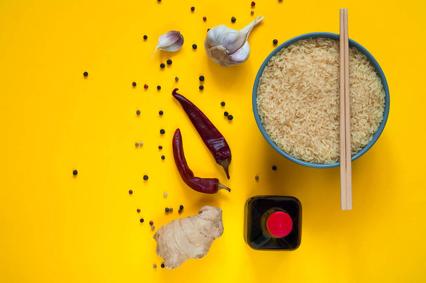 Asian food ingredients, spices and sauces on a yellow background. The concept of the most popular Chinese dishes, copy space - Photo, Image