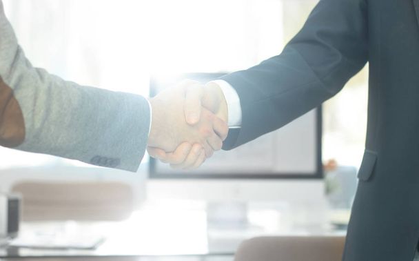 Nahaufnahme. Die Finanzpartner schütteln Hände über einem Schreibtisch - Foto, Bild