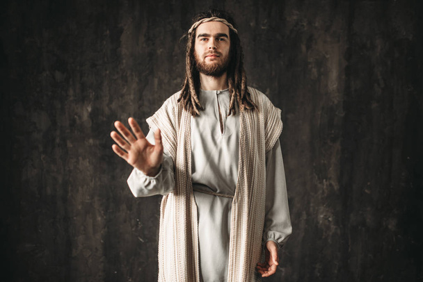 Jeesus Kristus valkoisessa kaapussa tummalla taustalla, rauhan symboli, kristillinen usko
 - Valokuva, kuva