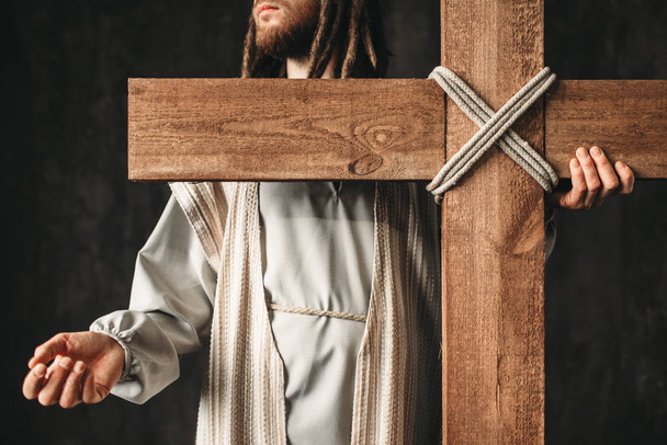 großer Märtyrer mit Kreuz, schwarzer Hintergrund, Kreuzigung des Jesus Christus, Symbol der christlichen Religion - Foto, Bild