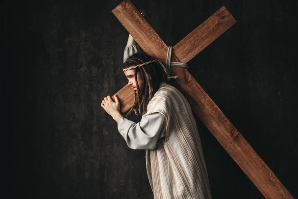 grote martelaar met kruis, zwarte achtergrond, kruisiging van Jezus Christus, symbool van de christelijke godsdienst - Foto, afbeelding