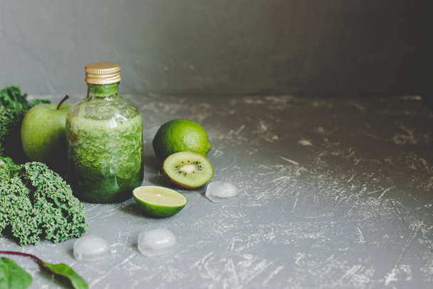 Healthy green smoothie with ingredients and ice cubes on gray background - Fotoğraf, Görsel