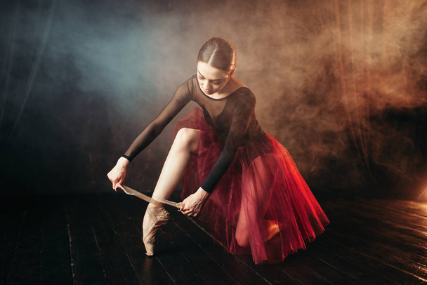 витончена і красива балерина в червоному костюмі прив'язана до взуття
 - Фото, зображення
