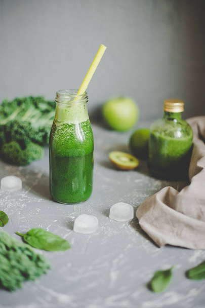 Healthy green smoothie with ingredients and ice cubes on gray background - Foto, Imagem