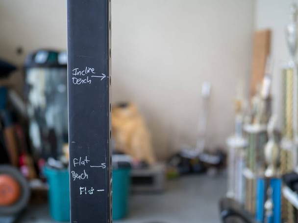 Marcadores de ejercicio garabateados apresuradamente en estante de peso
 - Foto, Imagen