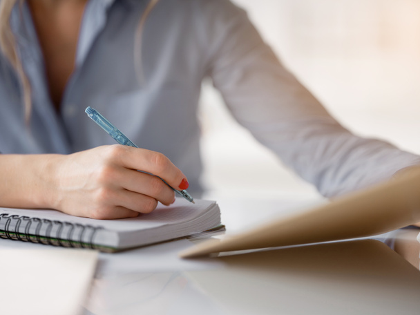 Businesswoman making notes in notebook - Photo, Image
