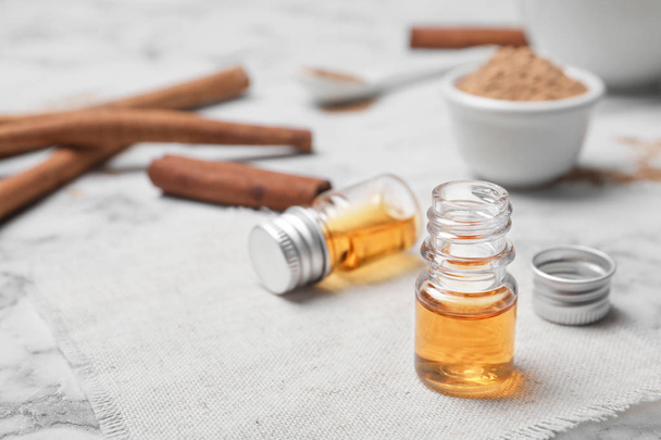 Closeup of bottle with cinnamon oil on light background - 写真・画像