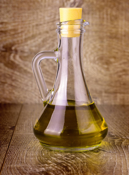 Extra virgin healthy Olive oil on wooden surface - Photo, image