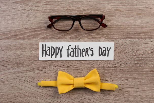 Bow tie and glasses on wooden background. Father's day celebration - Valokuva, kuva