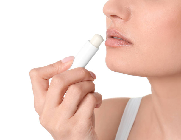 Mulher aplicando bálsamo higiênico labial, sobre fundo branco
 - Foto, Imagem