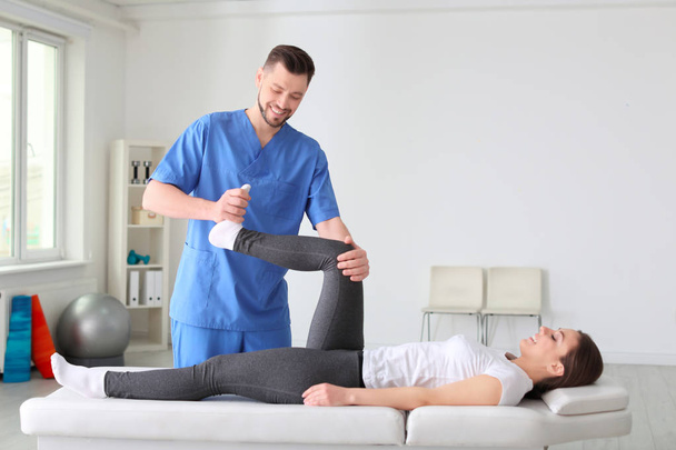 Physiotherapist working with female patient in clinic - Photo, image