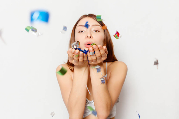 brunette woman with long hair smiling and confetti falls everywhere. - Foto, Imagem