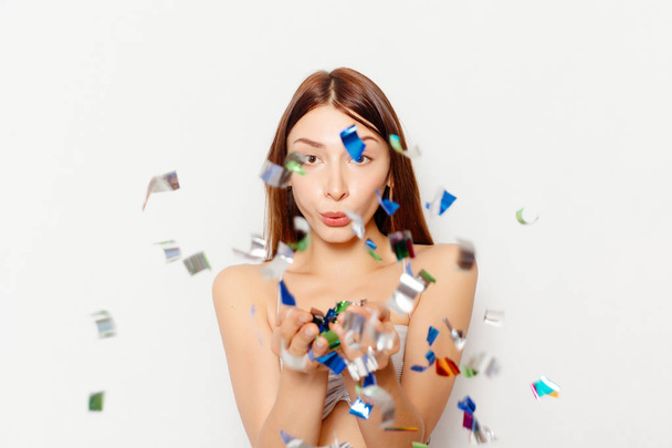 brunette woman with long hair smiling and confetti falls everywhere. - Foto, imagen