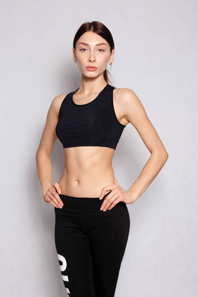 Pretty fit girl or fitness instructor posing and smiling - Zdjęcie, obraz