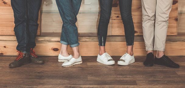 Male and female legs standing on wooden floor - Foto, afbeelding