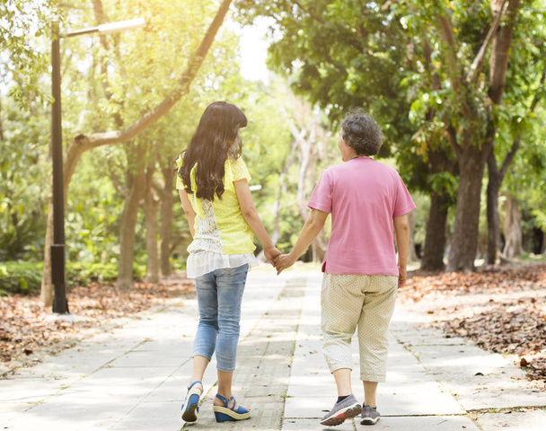 senior mother with daughter walking in the park - Photo, Image