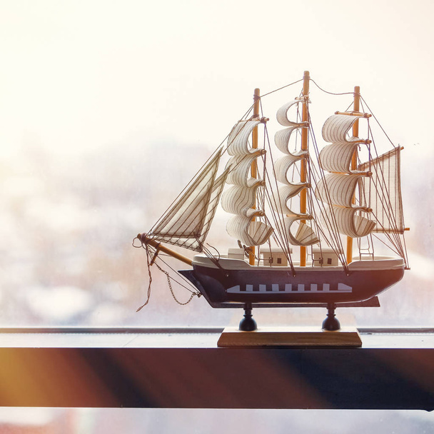 The model of a sailing ship stands on a misted window. The concept of travel. Its time to go to the sea - Фото, изображение
