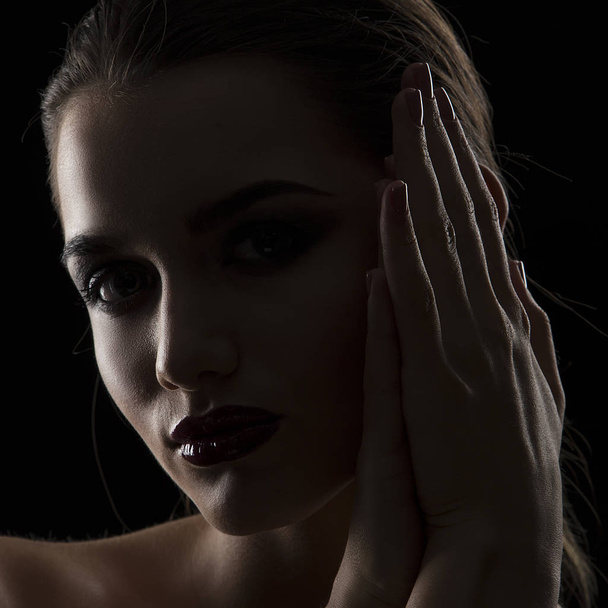 Portrait de femme aux lèvres sombres dans l'obscurité
 - Photo, image