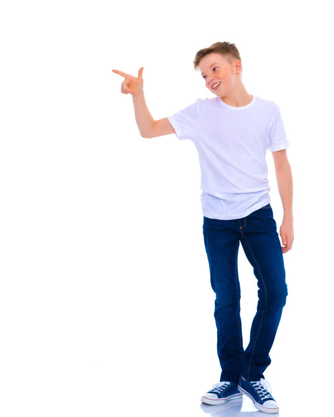 A beautiful little school boy points to something. - Фото, изображение