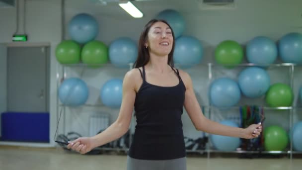 Beautiful woman jumping rope in the gym. The concept of a healthy lifestyle - Footage, Video