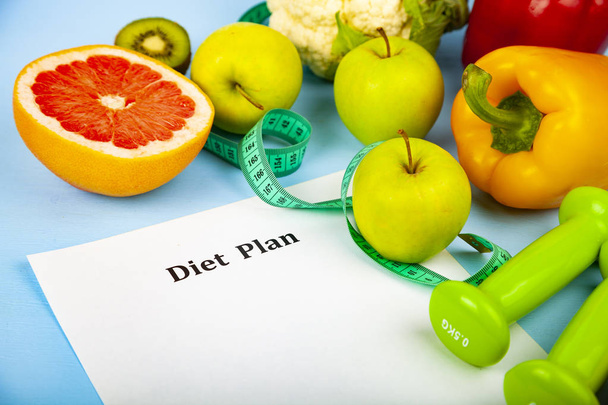 Voedsel en vel papier met een dieetplan - Foto, afbeelding