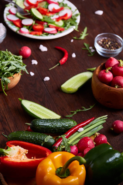 Creative fresh vegetable salad with ruccola, cucumber, tomatoes and raddish on white plate, selective focus - Valokuva, kuva