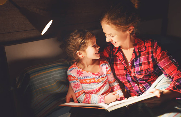 madre y el niño leyendo libro en la cama antes de ir a dormir
  - Foto, Imagen