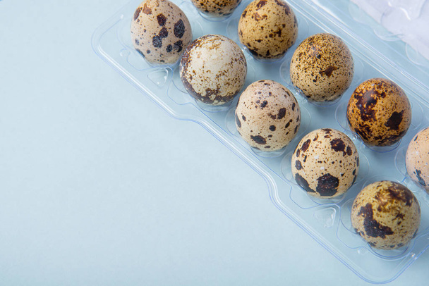 Beautiful spotted fresh quail eggs on a blue paper background - Photo, image