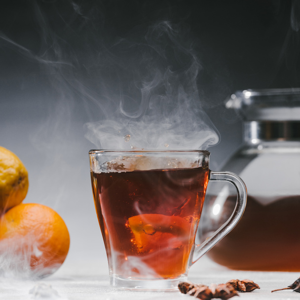 Steaming cup of spicy black tea with lemon - Photo, Image