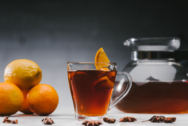 Chá preto quente na xícara com limões e laranjas
 - Foto, Imagem