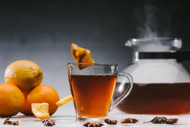 Black tea in cup with lemons and star anise on table - Photo, Image