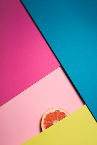 top view of slice of grapefruit on colorful surfaces - Photo, Image
