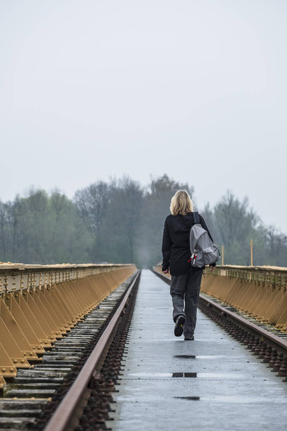 nő sétál magányos egy elhagyott vasúti híd - Fotó, kép