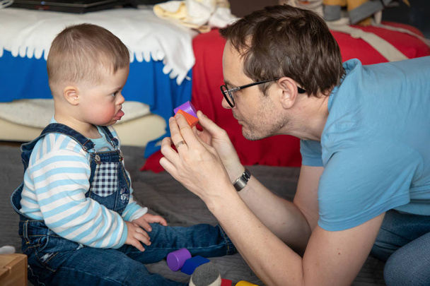 かわいい男の子はお父さんと遊ぶダウン症候群 - 写真・画像