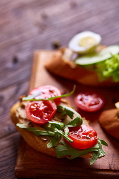 Breakfast sandwich with homemade paste, vegetables and fresh greens, shallow depth of field - 写真・画像