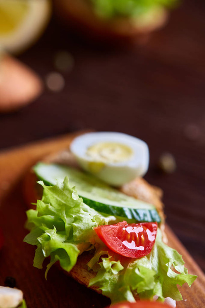 Breakfast sandwich with homemade paste, vegetables and fresh greens, shallow depth of field - Фото, зображення