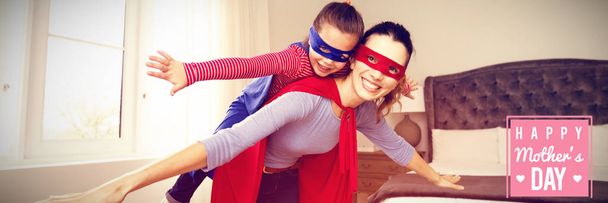 mothers day greeting against mother and daughter playing superwoman - Foto, imagen