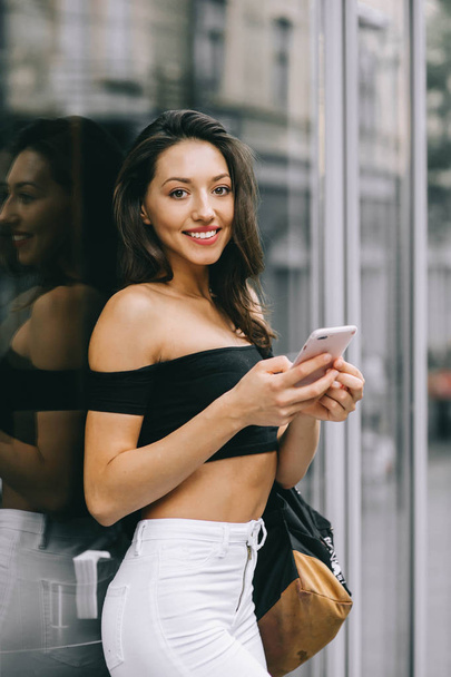 beautiful young woman using smartphone on the street  - Photo, image