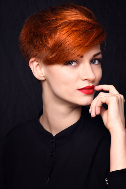 Portrait of a beautiful young red-haired woman with short hair on a dark background - Foto, Bild