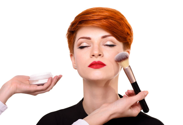 Maquillaje artista que trabaja con cepillo en la cara del modelo
. - Foto, imagen