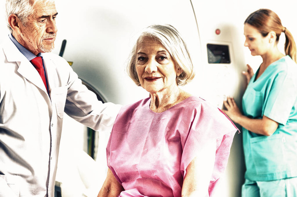 Ηλικιωμένη γυναίκα που υποβάλλονται σε ακτινογραφία που επικουρείται από τους γιατρούς. - Φωτογραφία, εικόνα