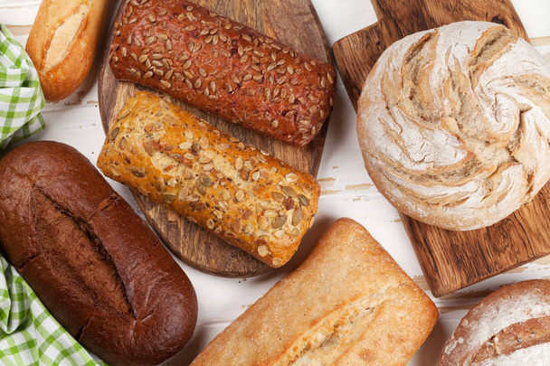 Διάφορα ξεροψημένο ψωμί και ψωμάκια σε άσπρο φόντο ξύλινη. Το Top view - Φωτογραφία, εικόνα
