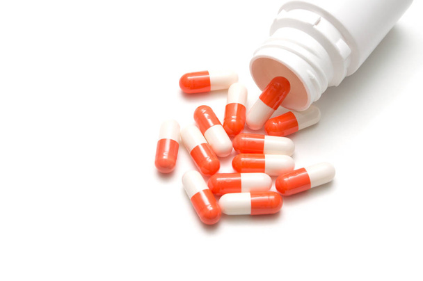 Флакон с таблетками и таблетками на белом фоне: медицинская концепция
 - Фото, изображение