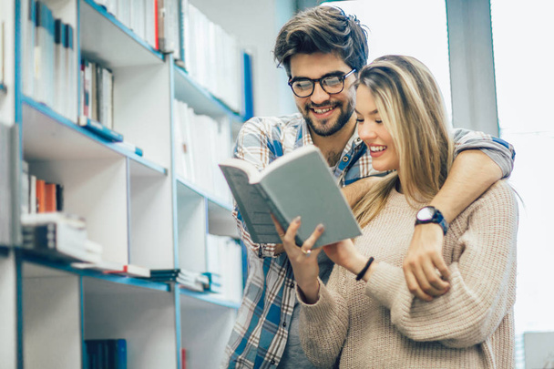Happy student couple with books in library - Zdjęcie, obraz