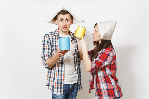 Young irritated woman, man in casual clothes holding empty paint tin can with copy space. Couple isolated on white background. Instruments, tools for renovation apartment room. Repair home concept. - Φωτογραφία, εικόνα