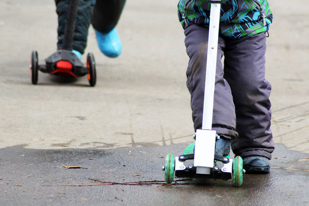 Bambini in sella a uno scooter, piedi
 - Foto, immagini