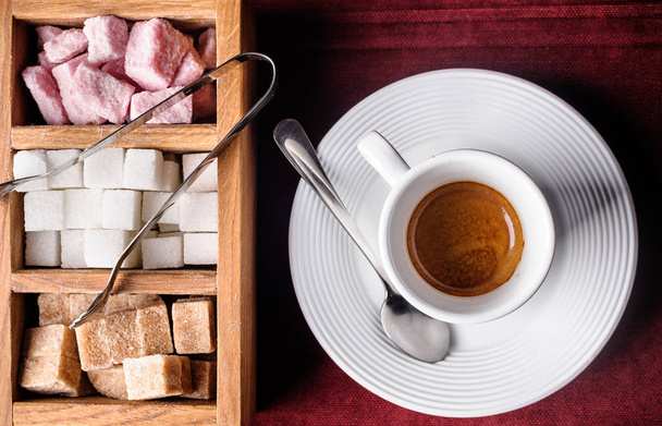 Espresso mit farbigem Zucker auf einer dunklen Tischdecke - Foto, Bild